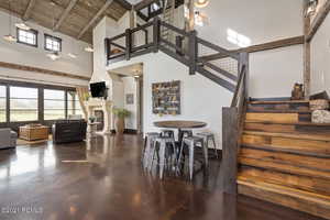 Dining room featuring wooden ceiling, a fireplace, finished concrete floors, and a healthy amount of sunlight