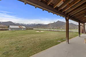 View of yard featuring an outbuilding, a rural view, a mountain view, fence, and a patio area