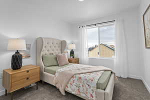 Bedroom with visible vents, baseboards, and dark colored carpet