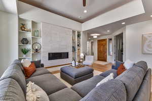 Living room featuring light wood-type flooring and built in shelves