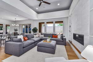 Living room featuring a tile fireplace, light hardwood / wood-style floors, plenty of natural light, and built in features