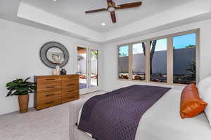 Carpeted bedroom featuring multiple windows, access to exterior, french doors, and a raised ceiling