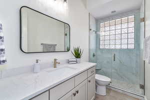 Bathroom with vanity, tile patterned flooring, toilet, and walk in shower