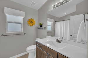 Bathroom with baseboards, visible vents, toilet, tile patterned flooring, and vanity