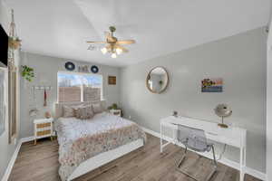 Bedroom featuring visible vents, baseboards, and wood finished floors