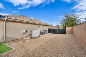 Back of house featuring central air condition unit, a fenced backyard, a tiled roof, and stucco siding