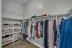 Walk in closet with wood finish floors