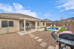 Back of house with a fenced in pool, a patio, stucco siding, a fenced backyard, and a tiled roof