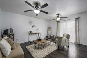 Living room featuring dark wood finished floors and baseboards