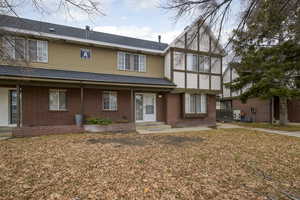 View of front facade with roof with shingles and brick siding