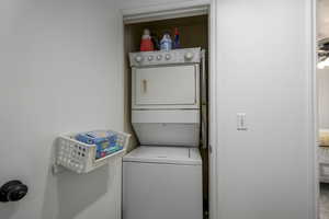 Clothes washing area with laundry area and stacked washing maching and dryer