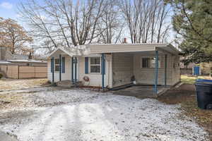 View of front facade with a carport and fence