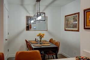 Dining area with baseboards and wood-style flooring