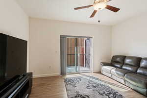 Living room with ceiling fan and wood-type flooring