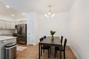 Dining area with light hardwood / wood-style floors and a chandelier