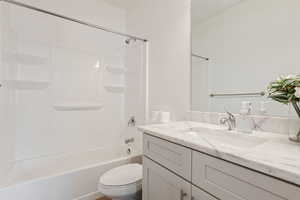 Full bathroom with bathtub / shower combination, toilet, and vanity