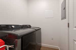 Laundry room featuring hardwood / wood-style floors, independent washer and dryer, and electric panel