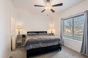 Carpeted bedroom featuring ceiling fan