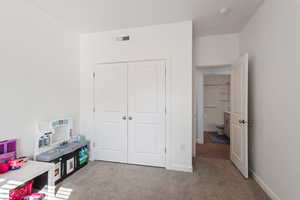 Carpeted bedroom featuring a closet