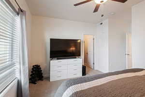 Carpeted bedroom featuring ceiling fan