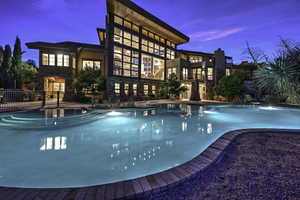 Pool at dusk featuring a patio area, an outdoor pool, and fence