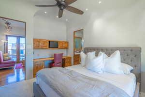 Bedroom featuring recessed lighting, a high ceiling, wood finished floors, a ceiling fan, and built in desk