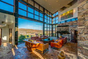 Living area with a mountain view, a high ceiling, a fireplace, visible vents, and floor to ceiling windows