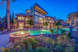 View of swimming pool featuring a pool with connected hot tub, a patio area, fence, and a fire pit