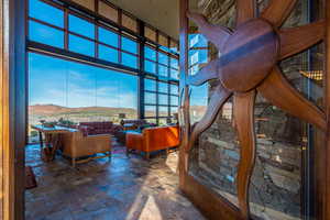 Interior space with stone finish floor, a mountain view, and a high ceiling