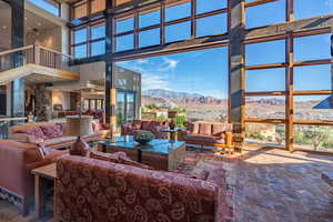 Interior space featuring a healthy amount of sunlight, a high ceiling, and a mountain view