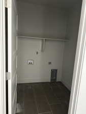 Laundry area featuring hookup for a washing machine, baseboards, dark tile patterned flooring, and laundry area
