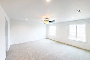 Unfurnished room with baseboards, visible vents, and light colored carpet