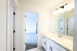 Bathroom with marble finish floor, vanity, and baseboards