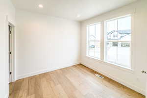 Unfurnished room featuring light wood finished floors, baseboards, visible vents, and recessed lighting