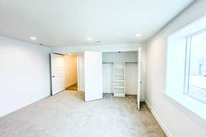 Unfurnished bedroom featuring recessed lighting, a closet, light carpet, and baseboards