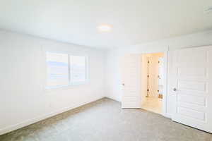 Unfurnished room with baseboards and light colored carpet