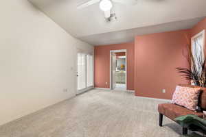 Sitting room with baseboards, visible vents, a ceiling fan, light colored carpet, and lofted ceiling