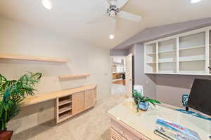 Home office with lofted ceiling, recessed lighting, a ceiling fan, light carpet, and built in study area