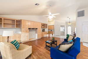 Living room featuring light wood-style floors, visible vents, high vaulted ceiling, and a ceiling fan