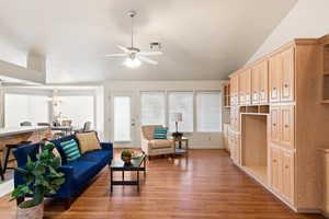 Living area with lofted ceiling, a ceiling fan, visible vents, and wood finished floors