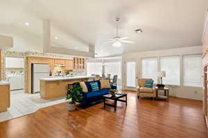 Living room with washer / dryer, a wealth of natural light, visible vents, and light wood-style floors