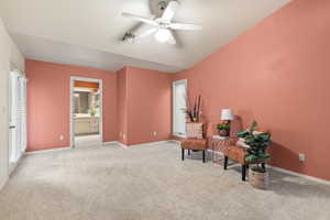 Living area featuring light carpet, baseboards, visible vents, and ceiling fan