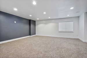 Carpeted empty room with recessed lighting and baseboards