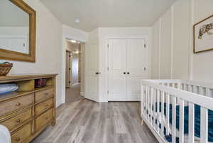 Bedroom featuring a closet, baseboards, and light wood finished floors