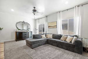 Living room featuring light wood-style flooring, baseboards, a ceiling fan, and recessed lighting