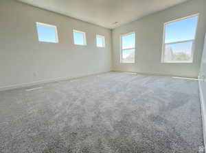 Carpeted empty room featuring visible vents and baseboards