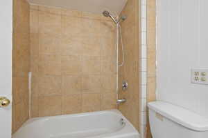 Bathroom featuring toilet and tiled shower / bath