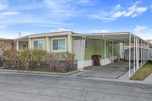 View of property exterior with a carport and a storage shed