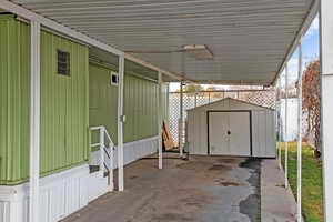 View of patio with a storage unit and a carport