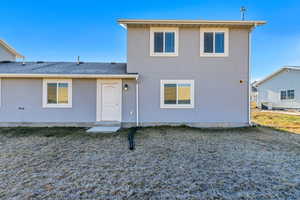 Back of property with roof with shingles and stucco siding